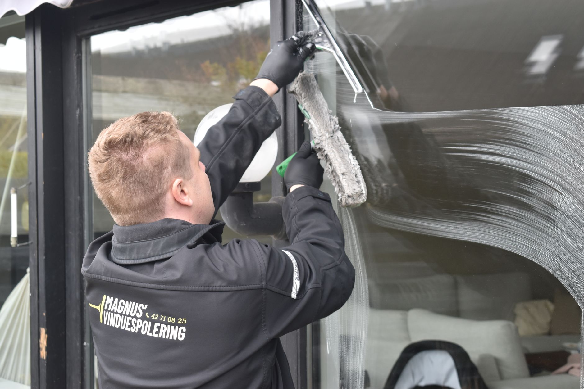 Fenster wird mit dem Abzieher streifenfrei geputzt